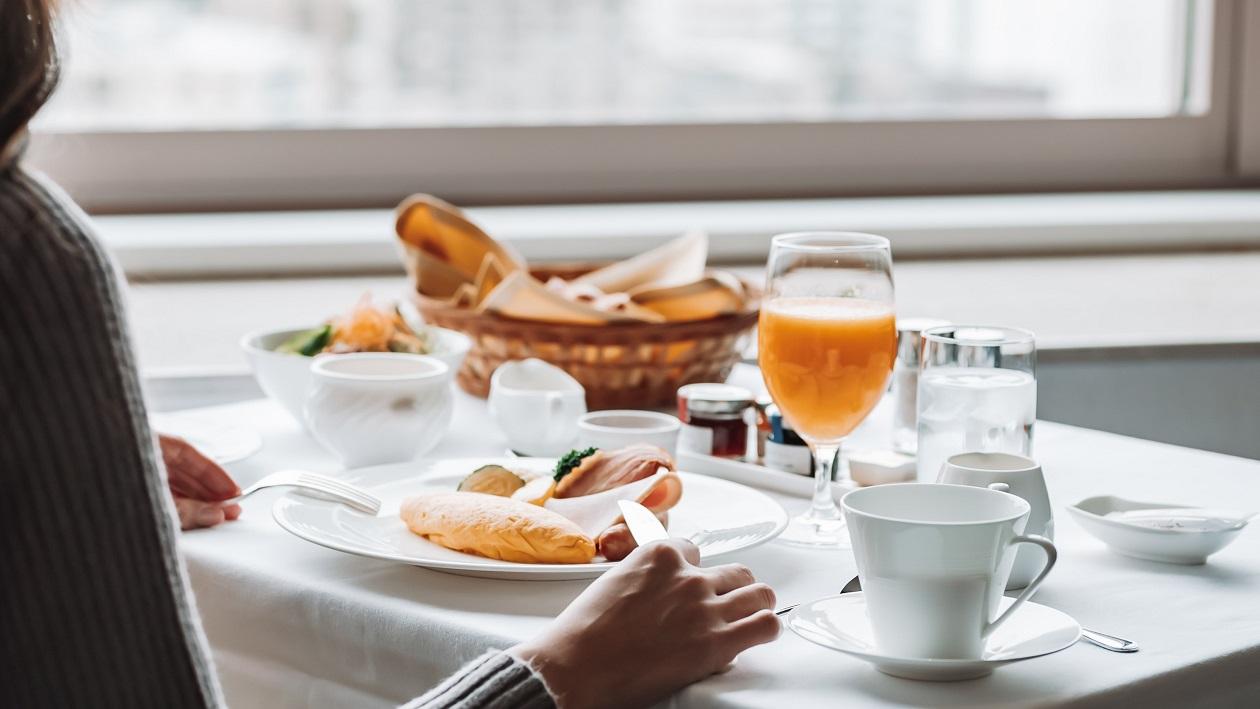 ザ・プリンス さくらタワー東京の「インルームダイニング」で、朝食を愉しむ女性客。
