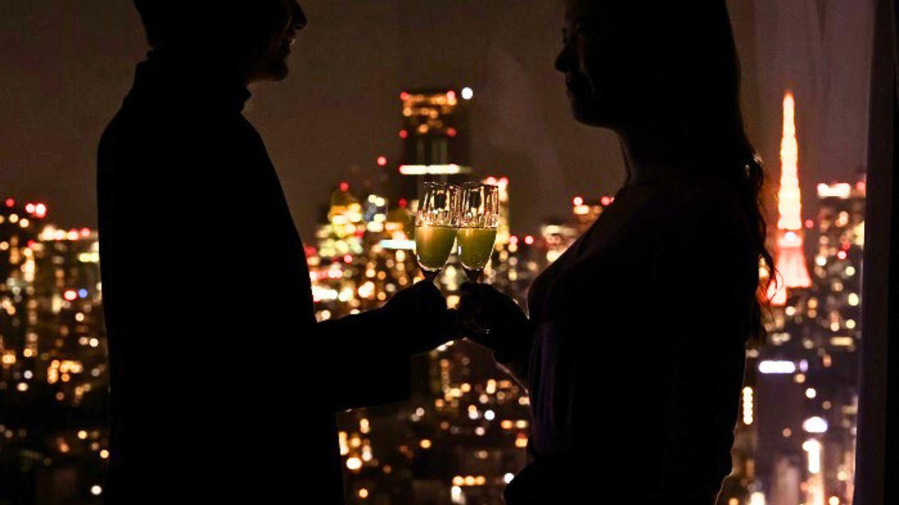 夜景を背景に乾杯するふたり