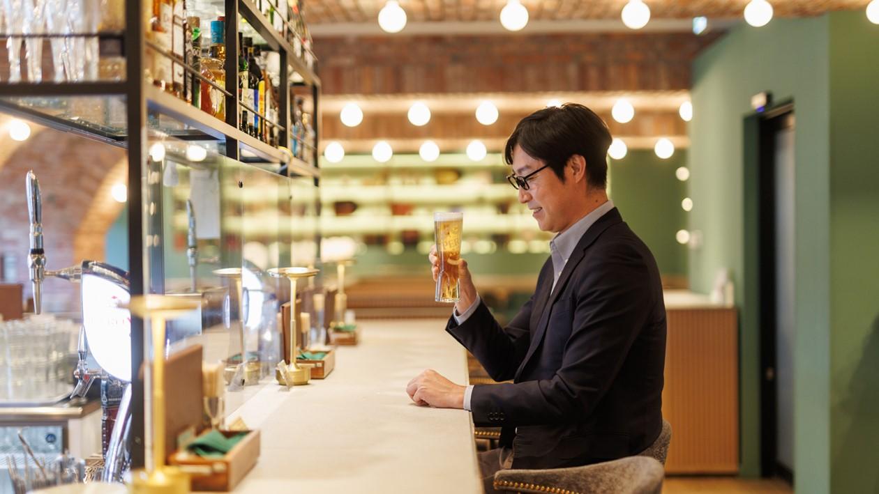 SHINAGAWA PIVOTのカウンターでビールを飲む男性