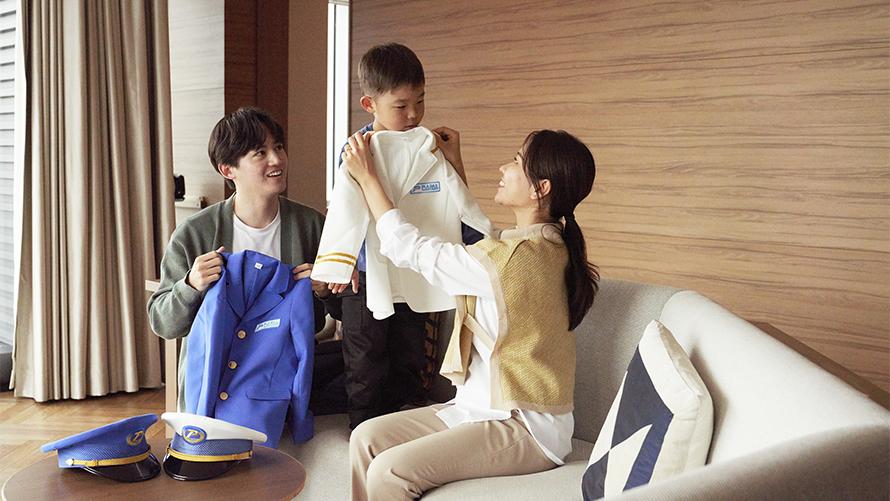 男の子がプラレール鉄道の制服を選んでいる