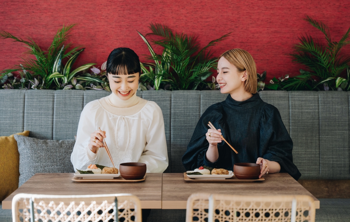 写真：食事前に女性二人が向かい合って手を合わせている様子