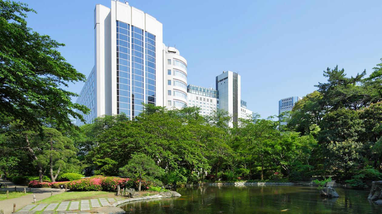 日本庭園を望み、白くそびえ立つグランドプリンスホテル新高輪の外観。